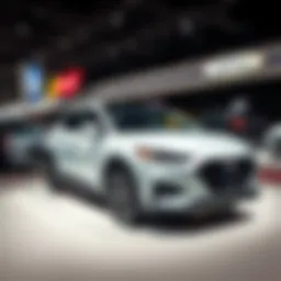 A hybrid car on display at a Detroit auto show with traditional gas vehicles in the background, highlighting the shift in consumer demand.