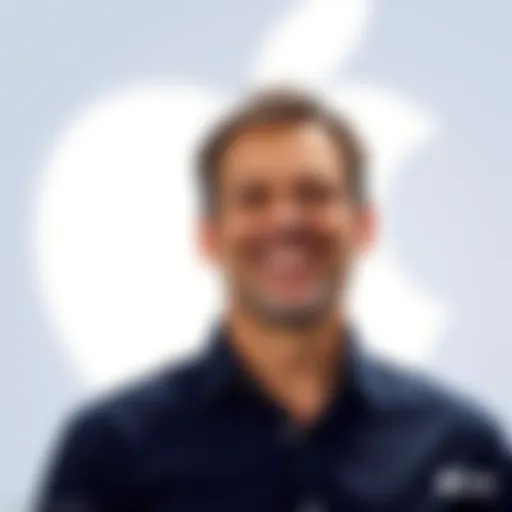 John Ternus smiling as he is announced as the new CEO of Apple, standing in front of an Apple logo