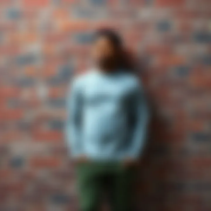 An individual dressed in gray, leaning against a reddish brick wall, representing their unique identity claim as a wall.